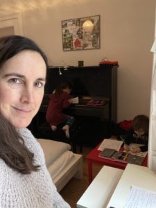 Frau mit zwei Kindern im Homeoffice