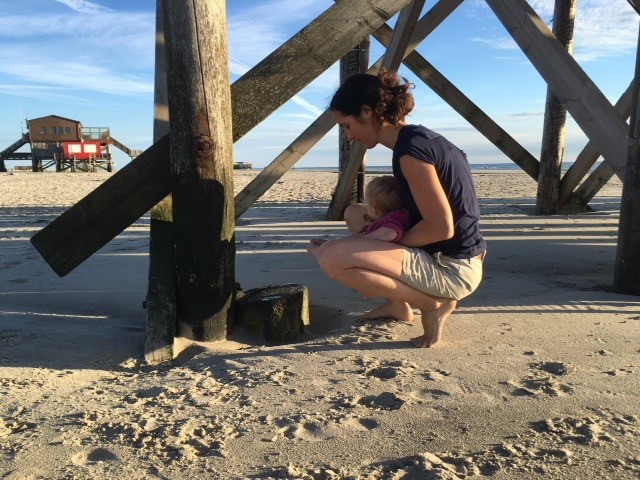 Frau mit Baby am Strand