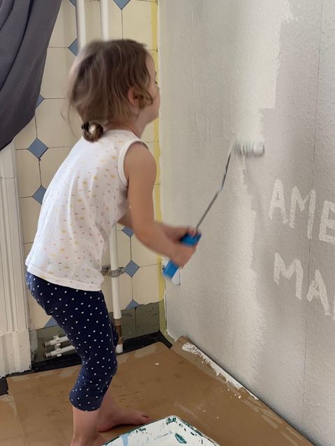 Kind streicht Wand an