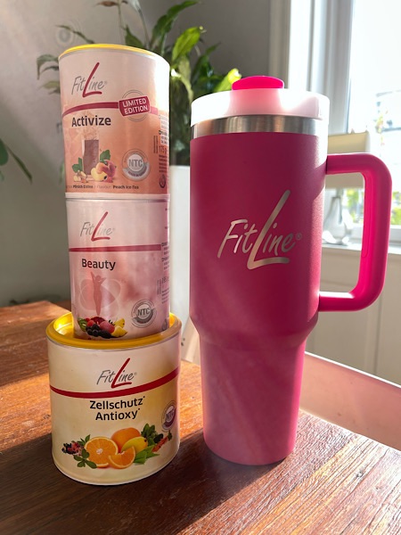 FitLine Produkte Active, Beauty und Antioxy neben einem großen pinken Stanley Cup von Fitline