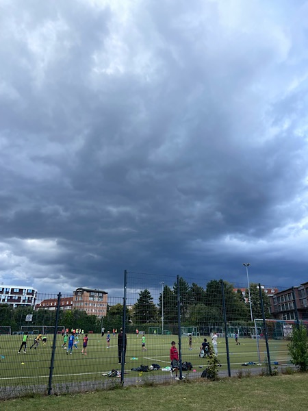 Dunkle Regenwolken über Fußballtrainingsgelände
