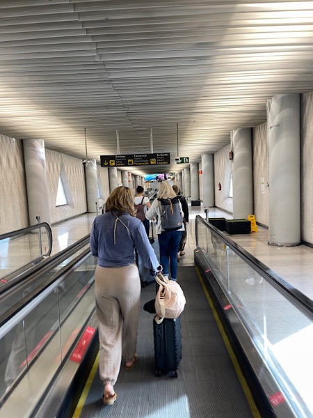 Frauen von hinten auf dem Rollband am Flughafen