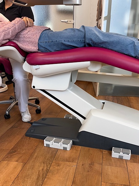 Person auf Behandlungsstuhl beim Zahnarzt