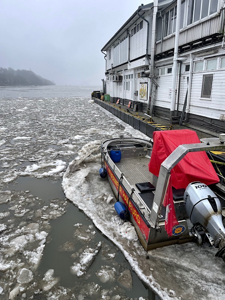 Am Fähranleger Teufelsbrück in Hamburg ein Boot der Feuerwehr im Wasser, umgeben von Eisschollen.