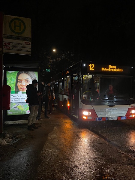 Bus Linie 12 abends im Regen an der Haltestelle Halbmondsweg